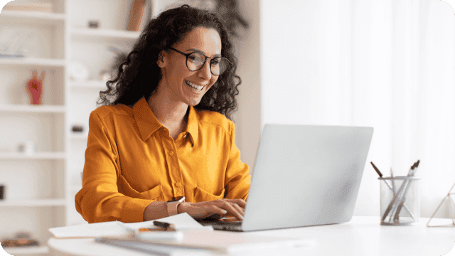 Jovem e sorridente empreendedora trabalhando no notebook